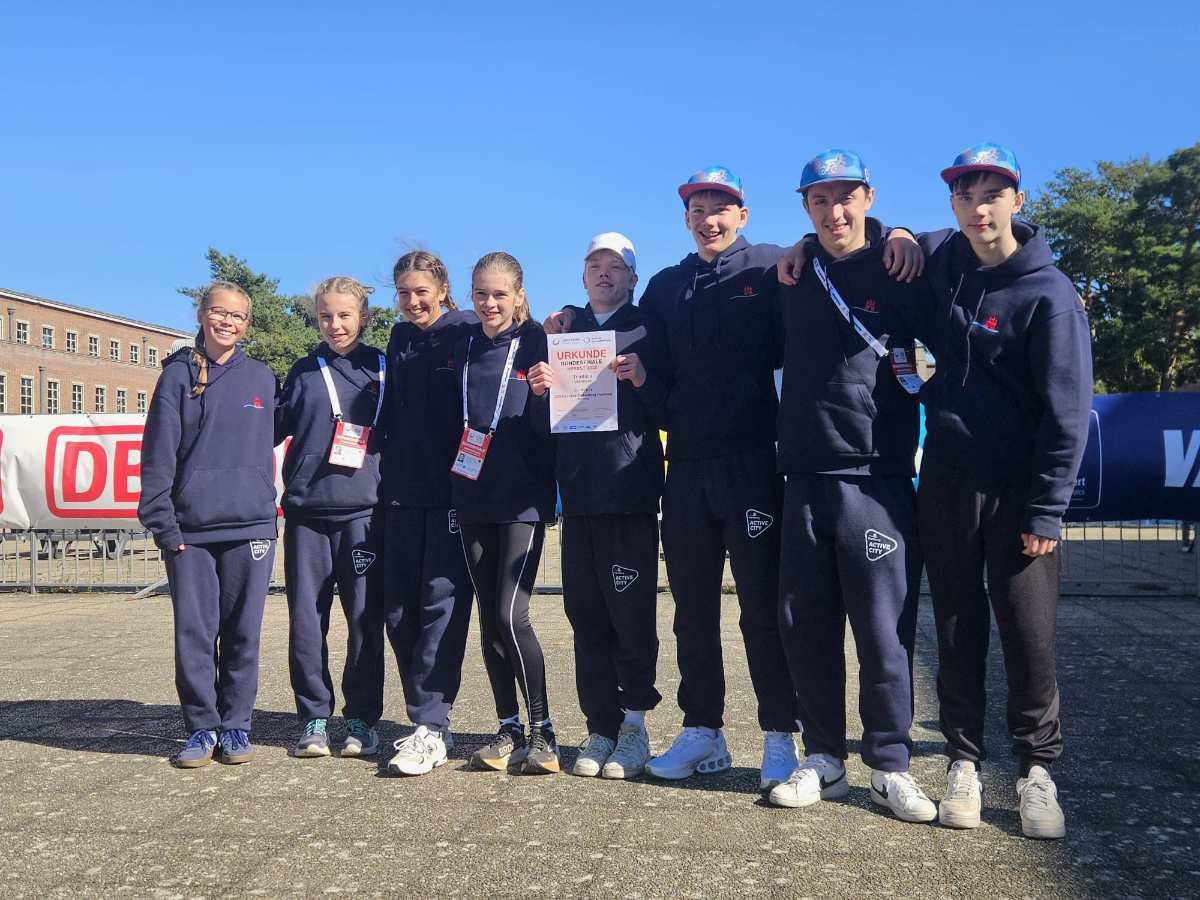 Gruppe von Sportlern mit Urkunde