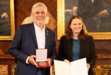 Zwei Personen mit Auszeichnung und Urkunde.
