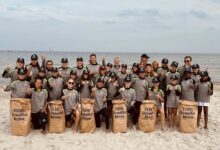 Gruppe bei Strandreinigungsaktion am Meer