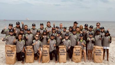 Gruppe bei Strandreinigungsaktion am Meer