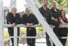 Fünf Personen in schwarzer Kleidung.