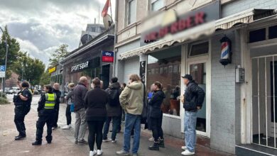 Menschen warten vor einem Friseur.
