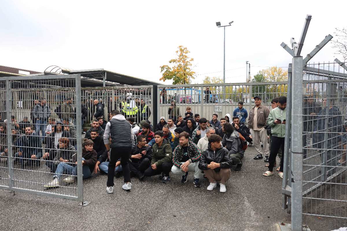 Menschenmenge hinter einem Zaun.