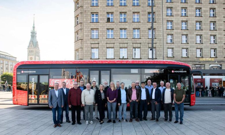 360 Jahre unfallfrei: HOCHBAHN-Fahrer für herausragende Sicherheitsleistung geehrt 6 Gruppe vor rotem Bus auf Platz