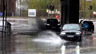 Autos fahren durch überflutete Straße.