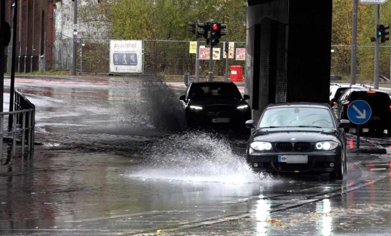 Autos fahren durch überflutete Straße.