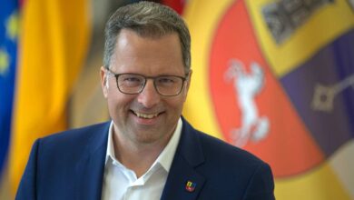 Mann in Anzug vor Flaggen