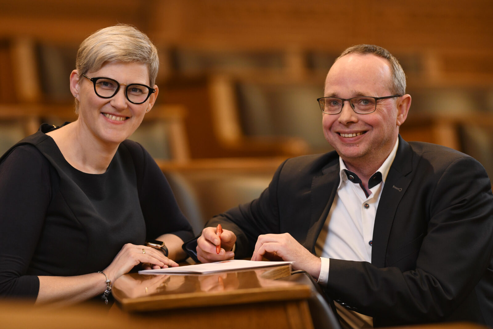 Zwei Personen diskutieren in der Sitzung.