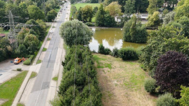 Grünes Gelände mit Teich und Straße