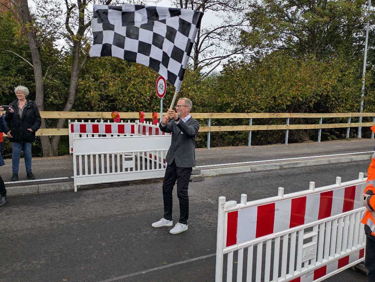 Mann mit Schachbrettflagge an Strecke