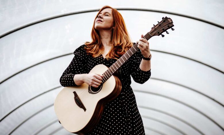 Konzert für die Seele: Marie Luise Gunst berührt mit Musik im Kulturhaus Süderelbe 4 Frau mit Gitarre in einem Bogen