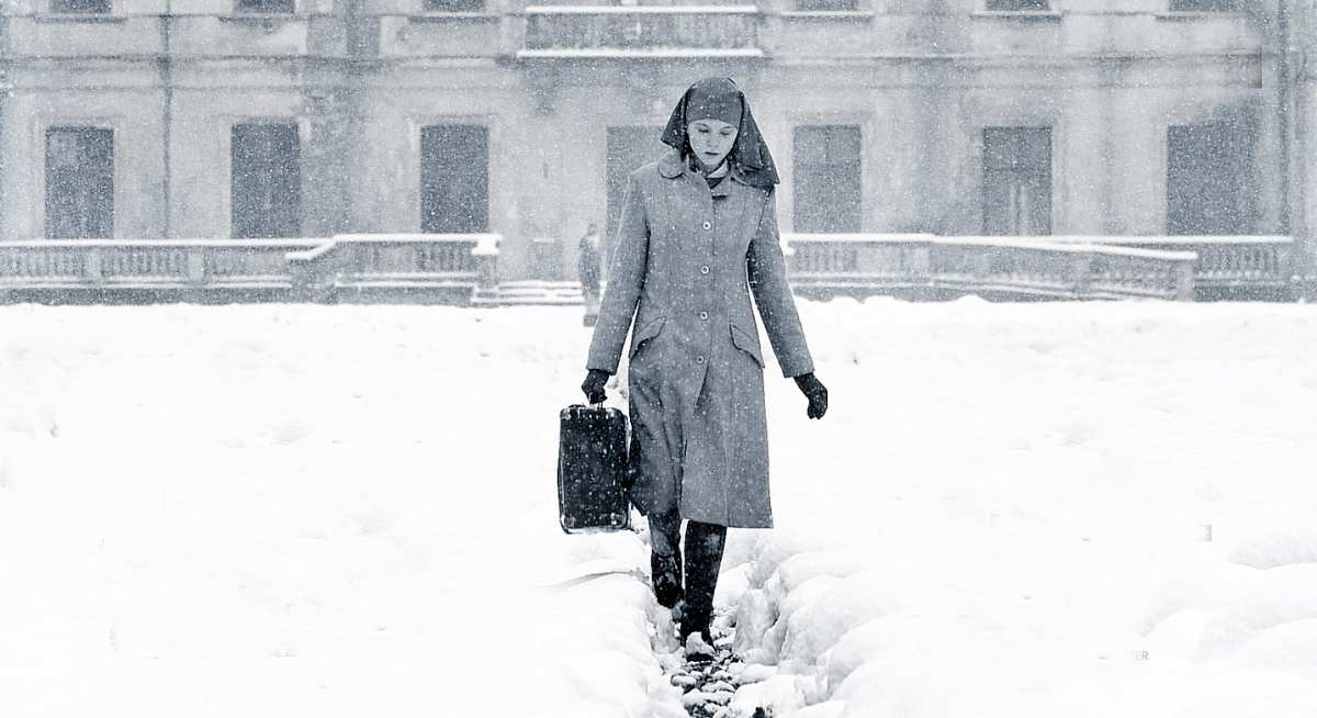 Frau im Schnee mit Aktentasche.