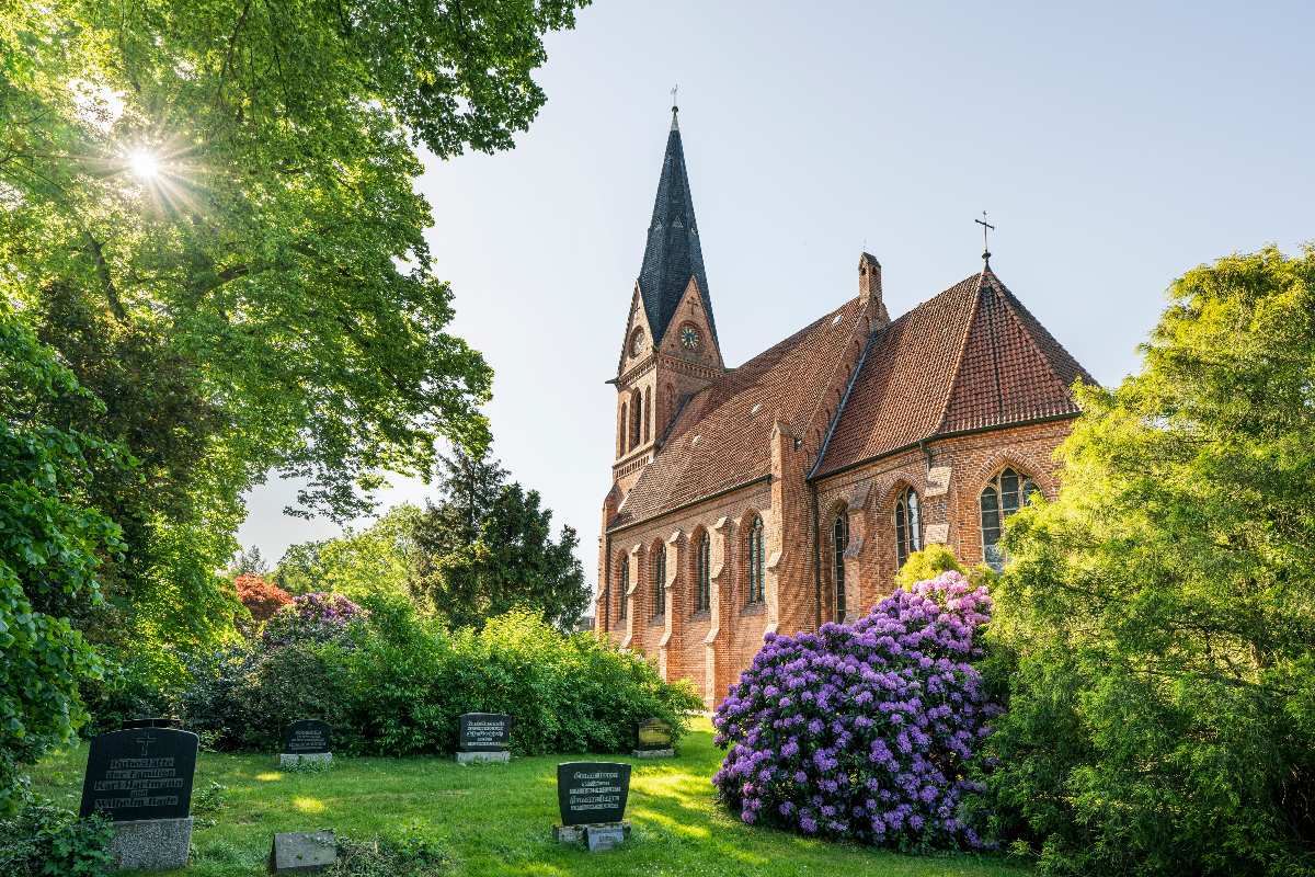 Schöne Kirche umgeben von Blumen.