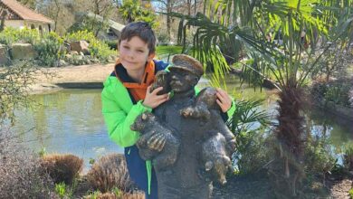 Junge mit Statue in der Natur.