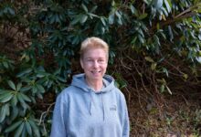 Frau vor grünen Pflanzen im Freien.