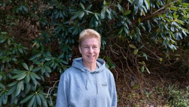 Frau vor grünen Pflanzen im Freien.