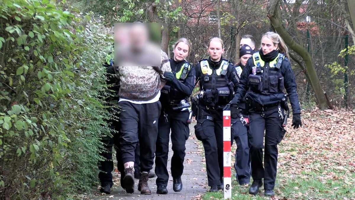 Polizisten begleiten festgenommenen Verdächtigen.