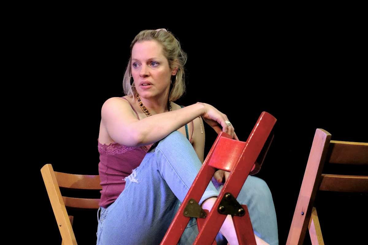 Frau sitzt entspannt auf Stuhl.