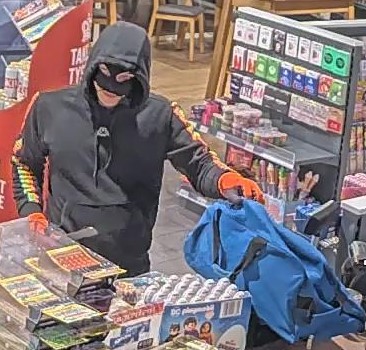 Maskierter Dieb im Geschäft