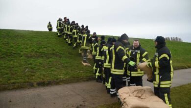 Feuerwehrleute arbeiten an Deichschutz.