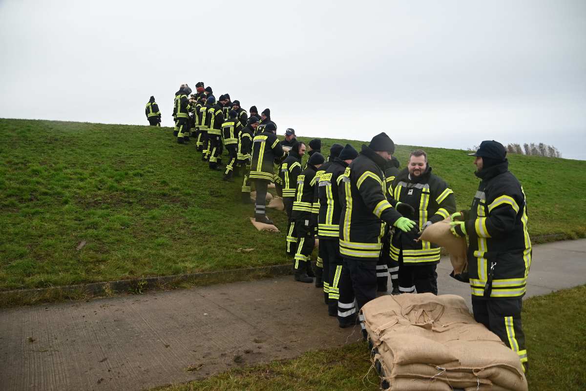 Feuerwehrleute arbeiten an Deichschutz.