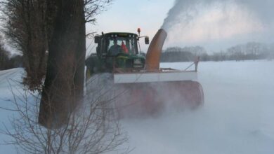 Schneepflug räumt verschneite Straße auf.