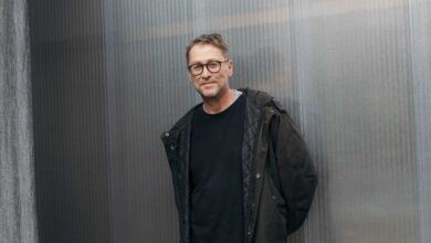 Mann in schwarzer Jacke steht.