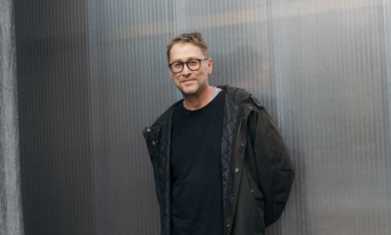 Mann in schwarzer Jacke steht.