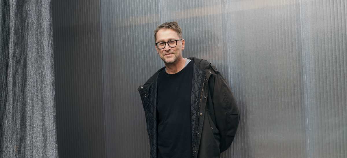 Mann in schwarzer Jacke steht.