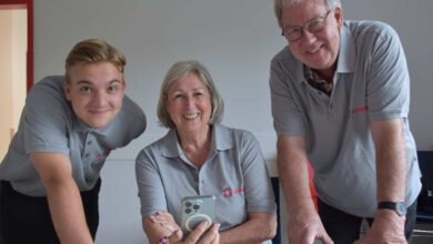 Drei Personen mit einem Smartphone