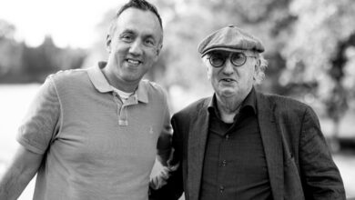 Zwei Männer stehen zusammen im Freien.