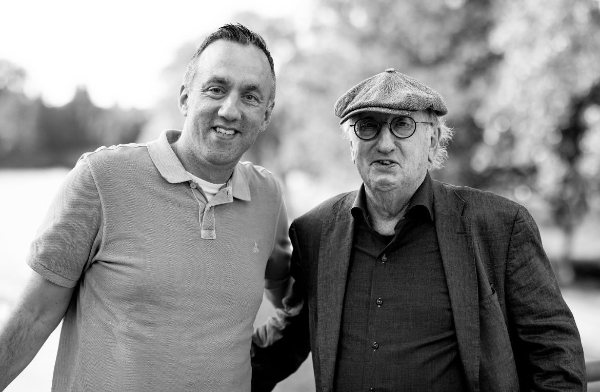 Zwei Männer stehen zusammen im Freien.