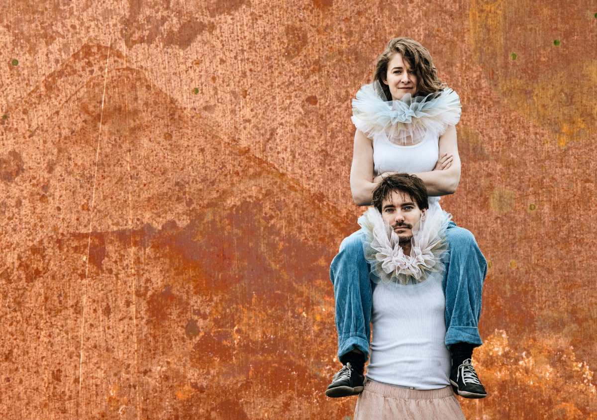 Junge sitzt auf den Schultern eines Mädchens.