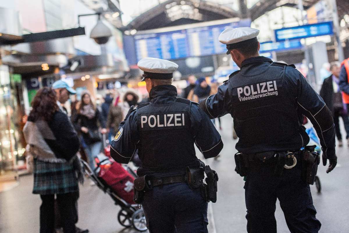 Polizisten patrouillieren in Bahnhofshalle.